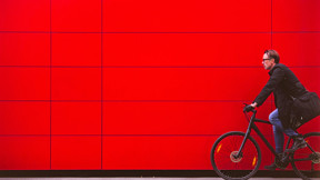 WILL BE DELETED SOON (safety issues) Man riding bicycle in front for red wall
iStock-627884444; Used for cover of Sustainability Report 2018. 

Vibrant Color; Real People; Travel; Male; Traveling; Businessman; Men; City Life; Commuter; Healthy Lifestyle; Caucasian Ethnicity; Business Travel; One Person; Vitality; On The Move; Red; Modern; Urban Scene; Outdoors; Horizontal; Cycling; Street; Bicycle;  Riding; Bike